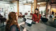 A business owner smiling at a customer across a service desk with a point of sale system.