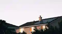 Solar panels installed on the roof of a suburban home at dusk.