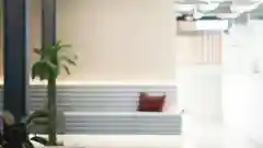 Two women push a cart with pink buns through an office building.