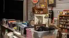 A variety of household items, including storage bins and miscellaneous goods, arranged on tables in a garage for a yard sale.