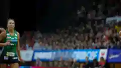 Maddy Proud playing netball in a stadium