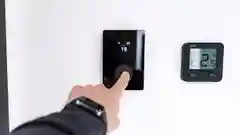 Close-up of a person setting the temperature on a smart home climate control device.