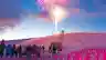 Crowds gather on a snow-covered slope at dusk as colourful fireworks burst above a ski resort under a vibrant twilight sky.