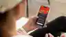 A woman looks at the red energy app on her mobile phone