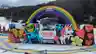 A colourful Thredbo sculpture display featuring a rainbow arch, alien figure, and floral designs with Red Energy branding.